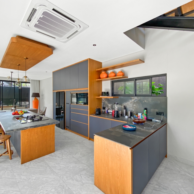 Open-concept kitchen with gray and wood cabinetry, an island, and a dining area.