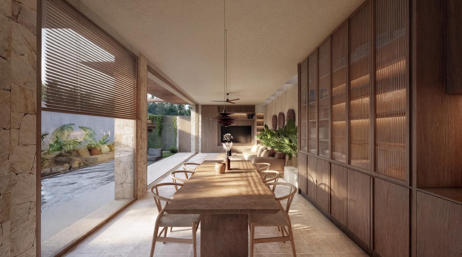 Open-plan dining room with a long wooden table and six wooden chairs, flanked by built-in timber cabinets, opening to a patio and living area with plants and a ceiling fan.