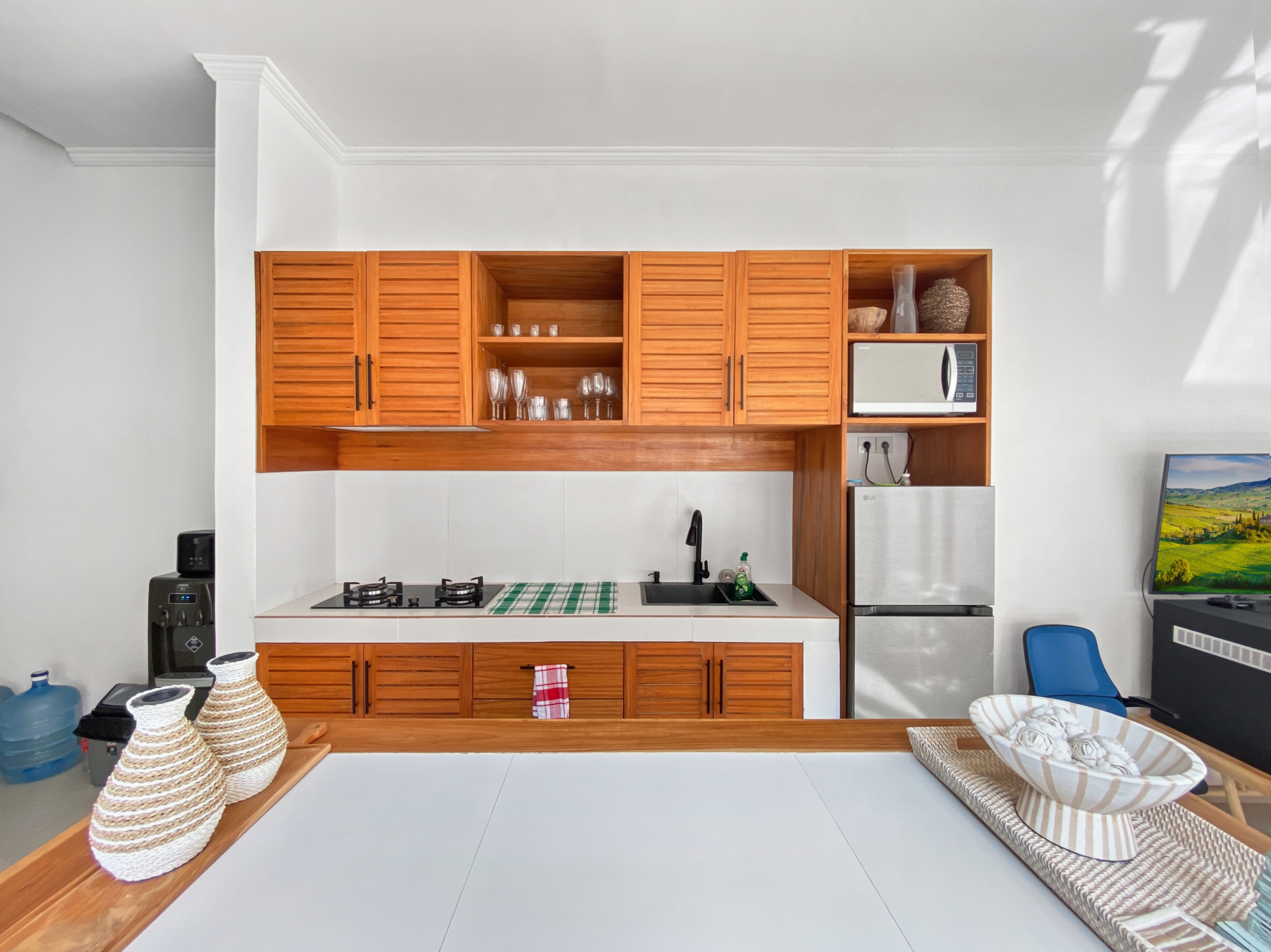 ca7854b3420230ed5203e6d7bbaa2483a62c281d Modern kitchen with warm wooden cabinets, white countertops, a gas stove, and a stainless steel sink.