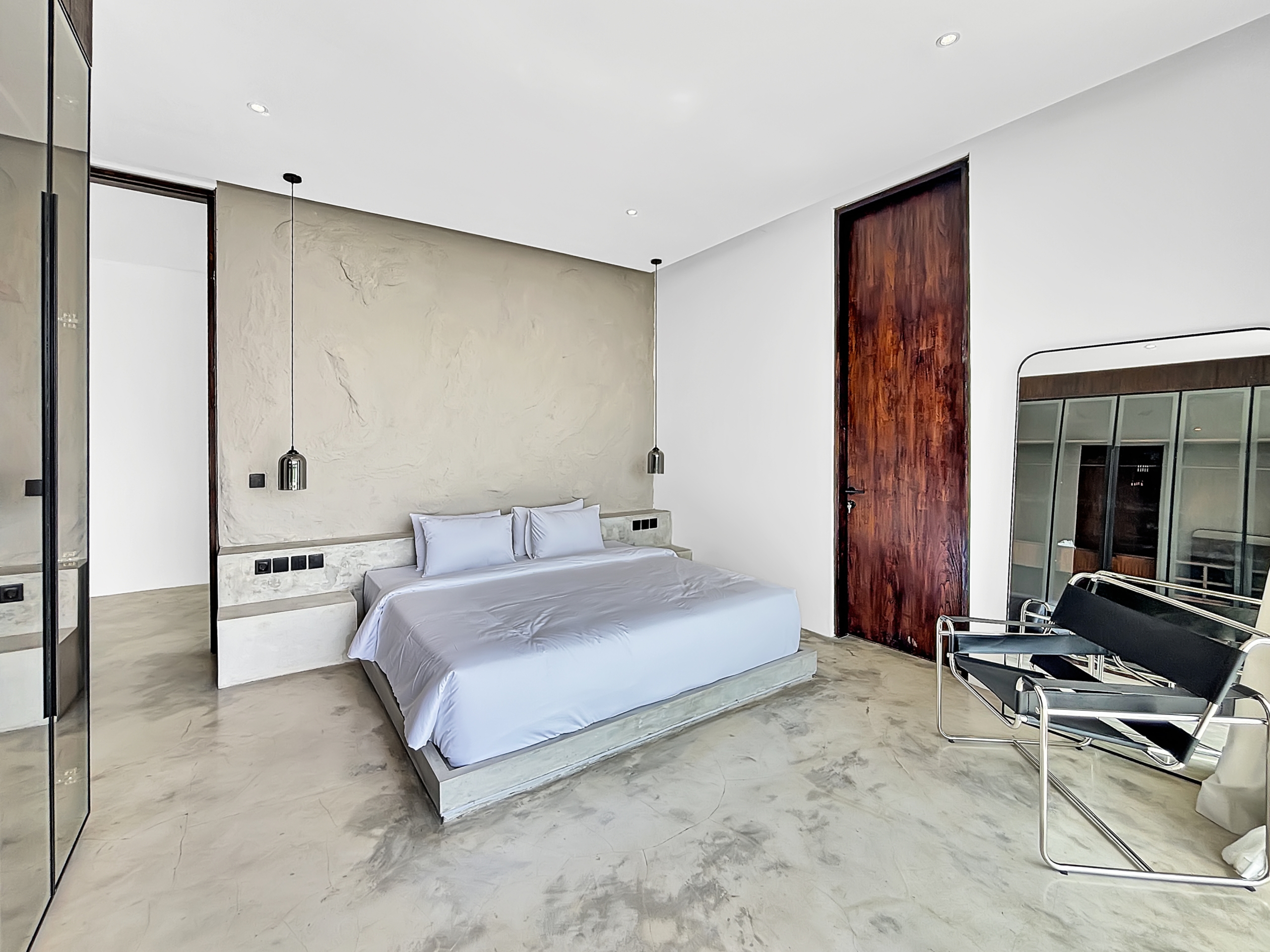 cbb7b87466b802d658340bd9409f062ca1f6ee38_6773-6a1d7baf0a580 Modern hotel-style bedroom with marble floor, low platform bed and two pendant lights on textured wall.