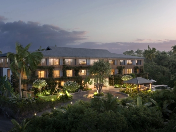 Three-story tropical resort with lit windows surrounded by palms and lush greenery at dusk/twilight.