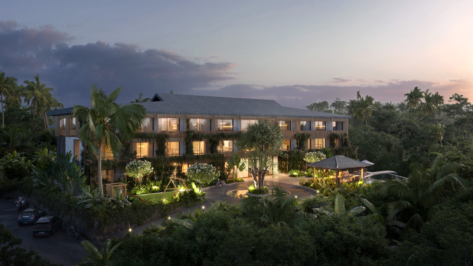 01_Concept_Visualization_Aerial_Evening Three-story tropical resort with lit windows surrounded by palms and lush greenery at dusk/twilight.